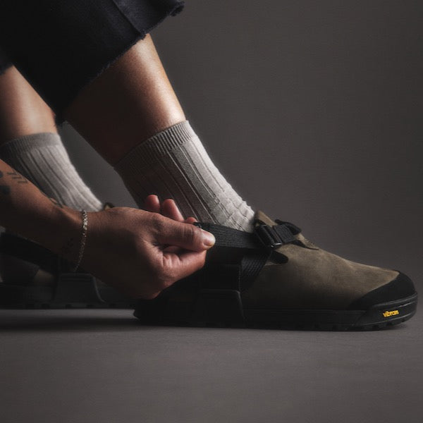 Person adjusting Mountain Clog by tightening ladder lock buckle