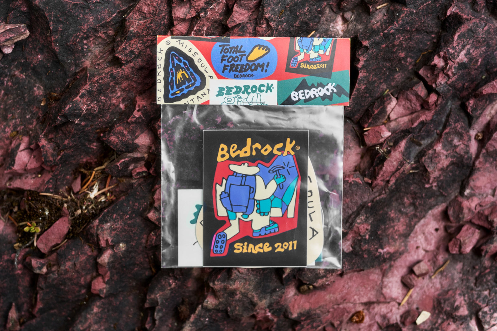 Bedrock 2026 sticker pack photographed on a red rock
