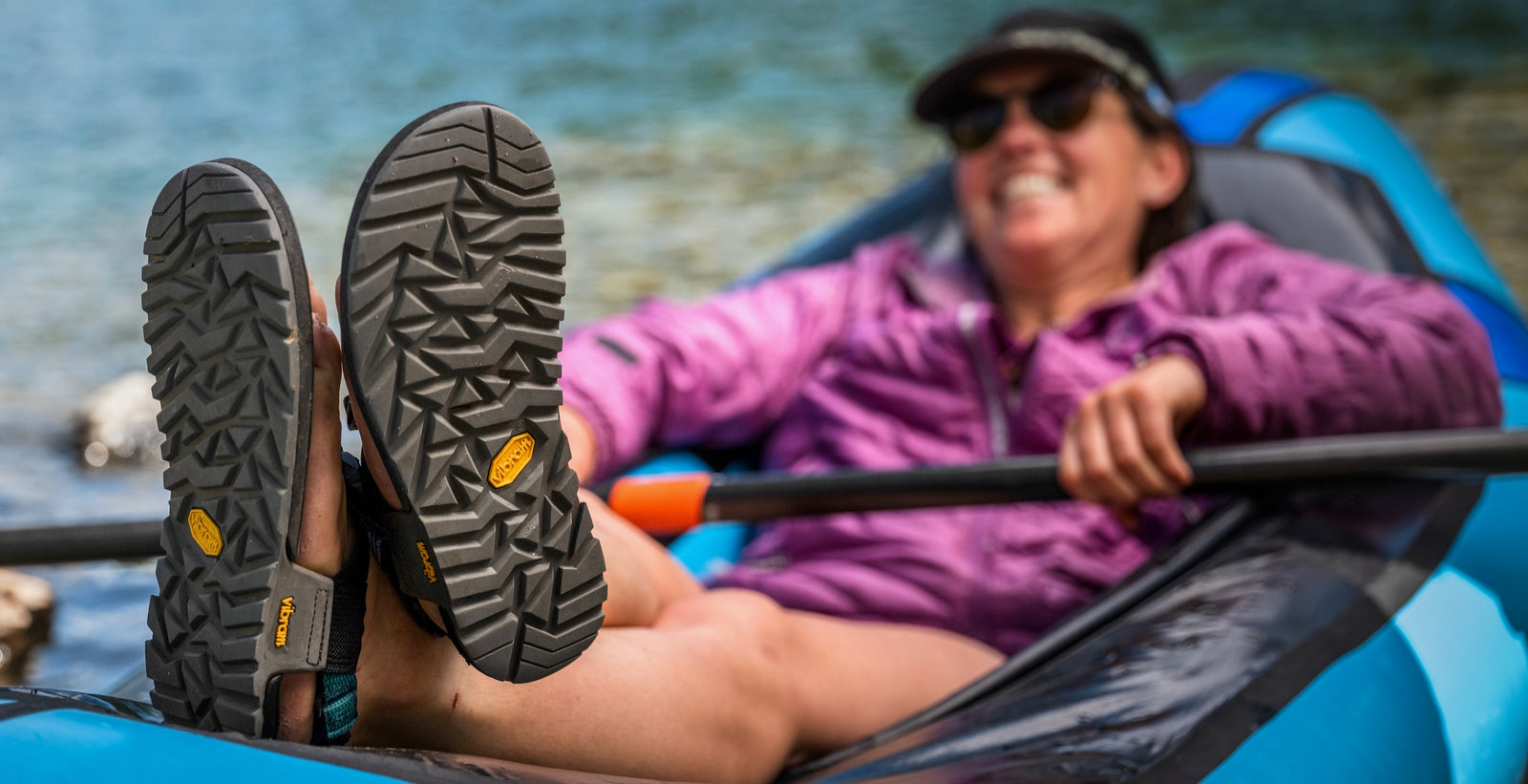 Person relaxing in packraft with feet up on the raft wearing cairn sandals