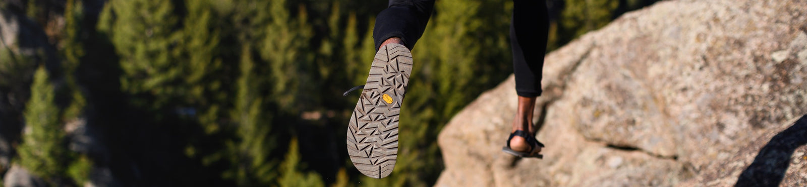 Person jumping between rocks wearing cairn sandals
