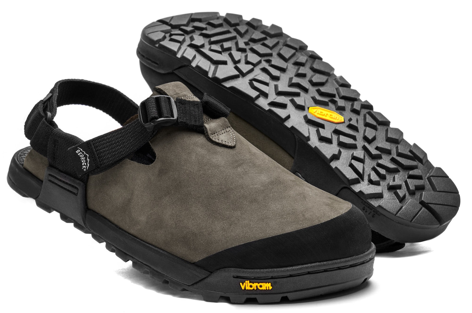 A pair of driftwood gray Nubuck leather mountain clogs with an adjustable strap and a thick, rugged black sole.