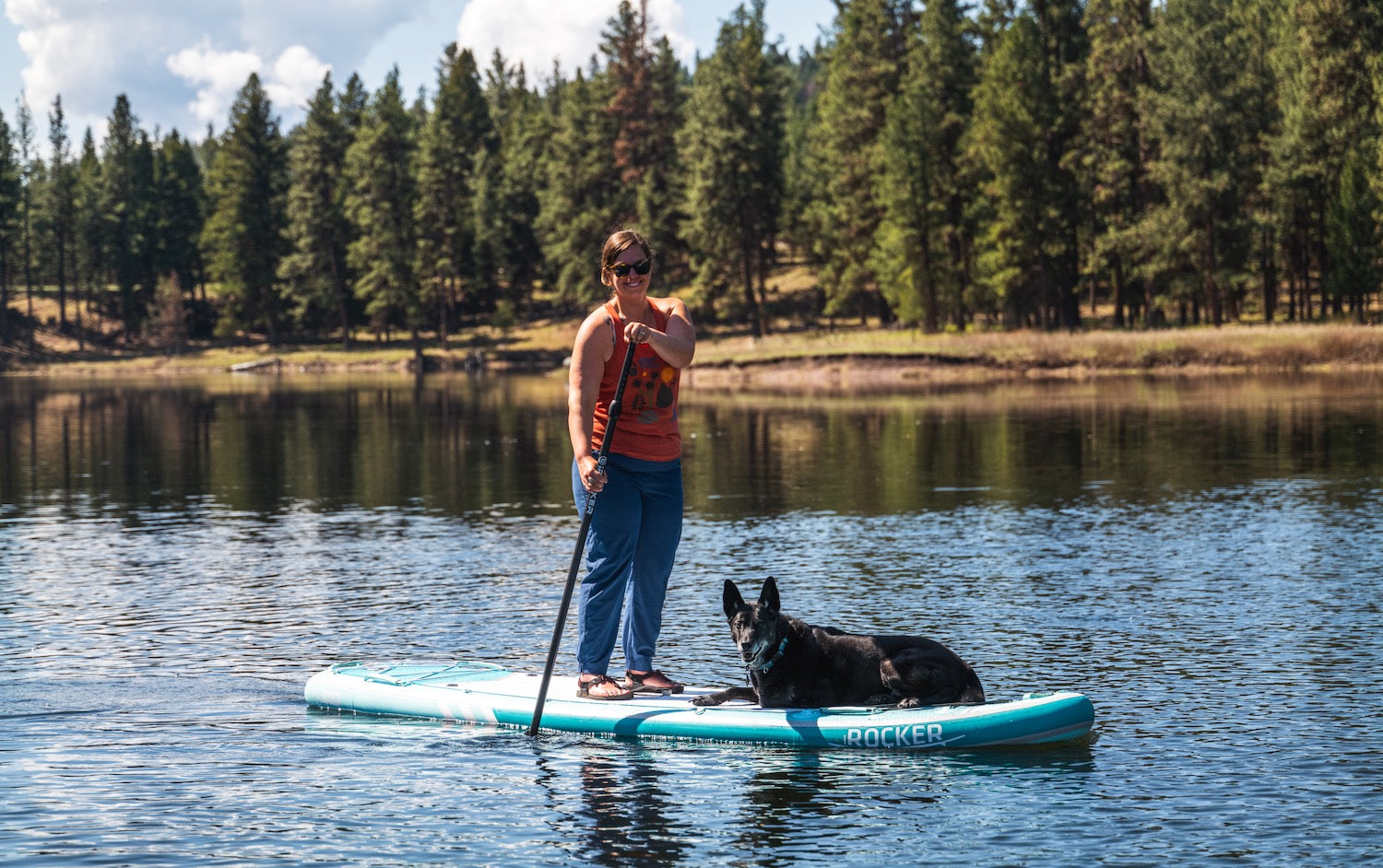 woman paddleboarding on a lake wearing Bedrock cairn sandals