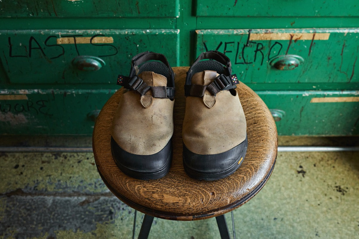 Worn Mountain Clogs displayed on a work stool