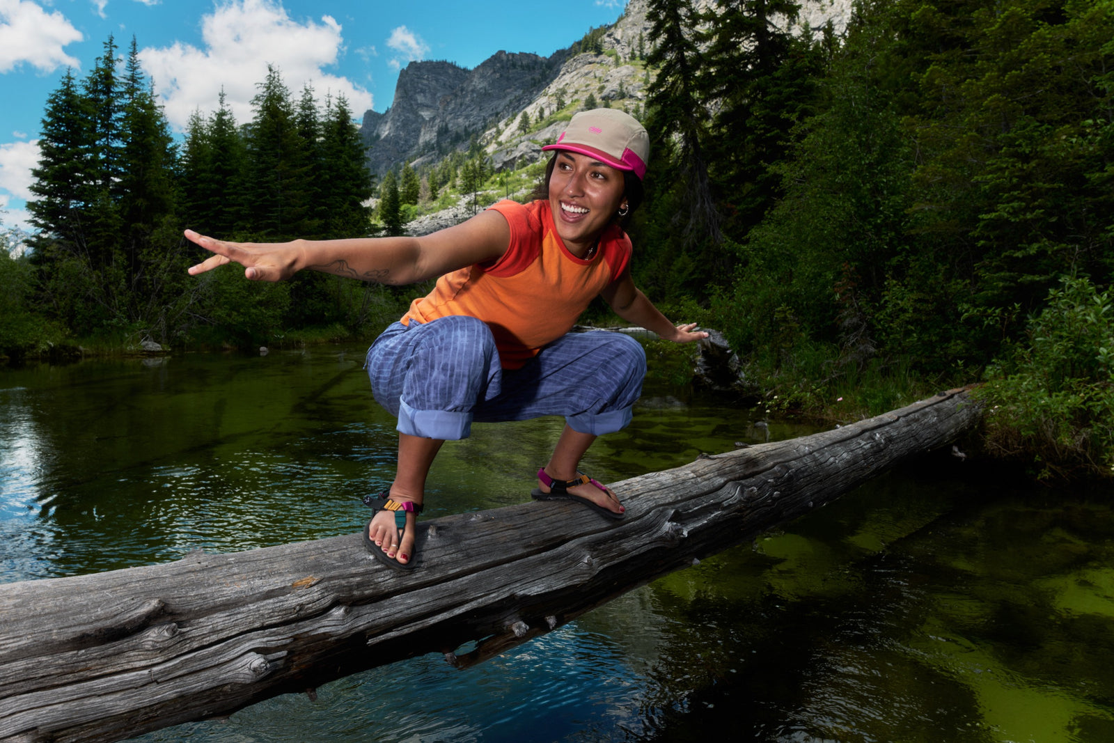 Person pretend surfing on a log wearing Bedrock cairn tourmaline metamorphic sandals