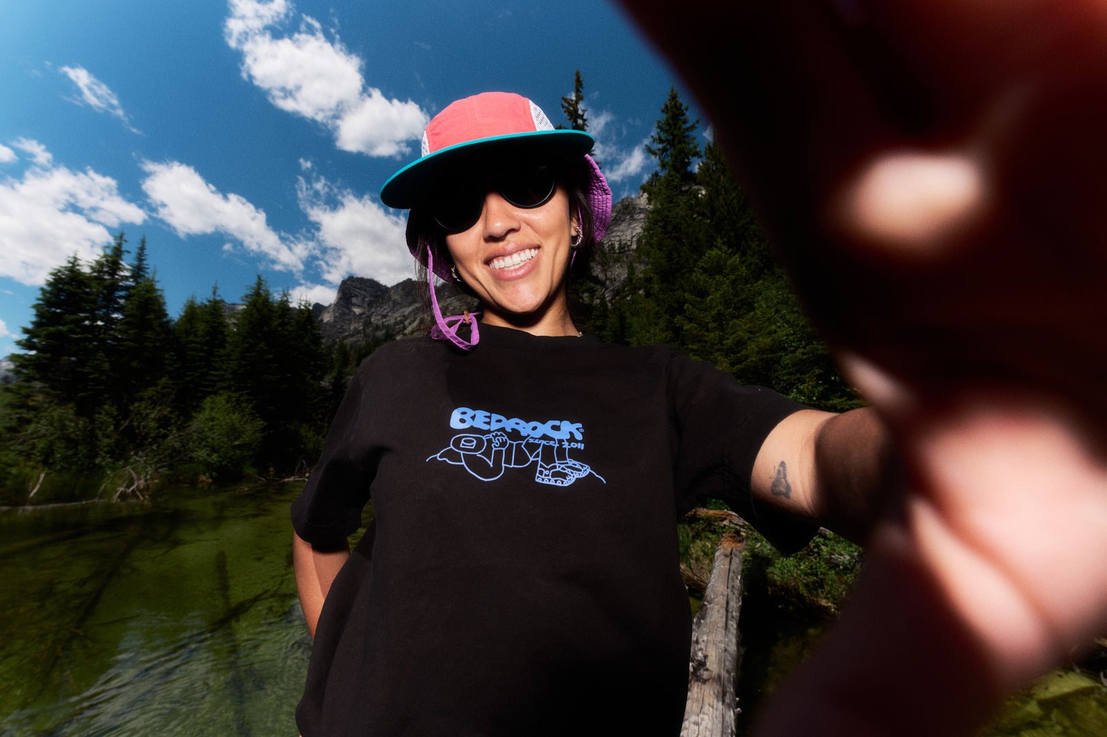 Person wearing black t-shirt with Bedrock Since 2011 written with a character illustration
