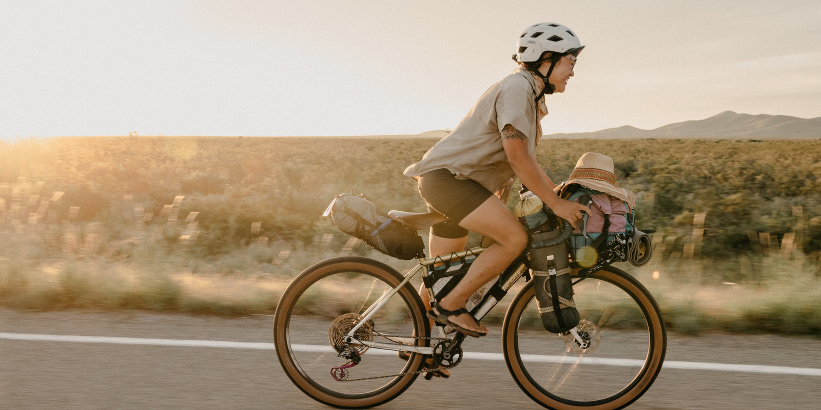 Person riding a bicycle on a road with a scenic background