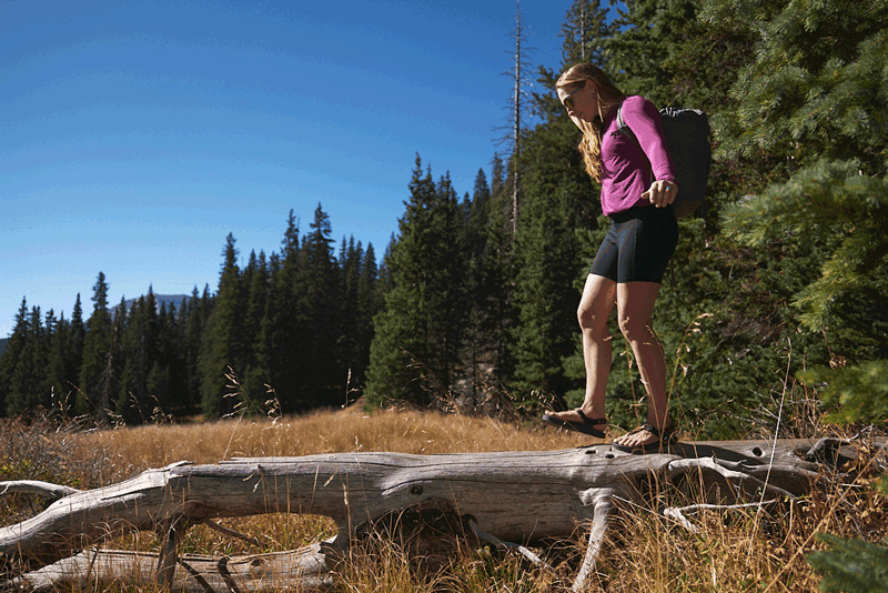 person walking on log wearing cairn evo c sandals