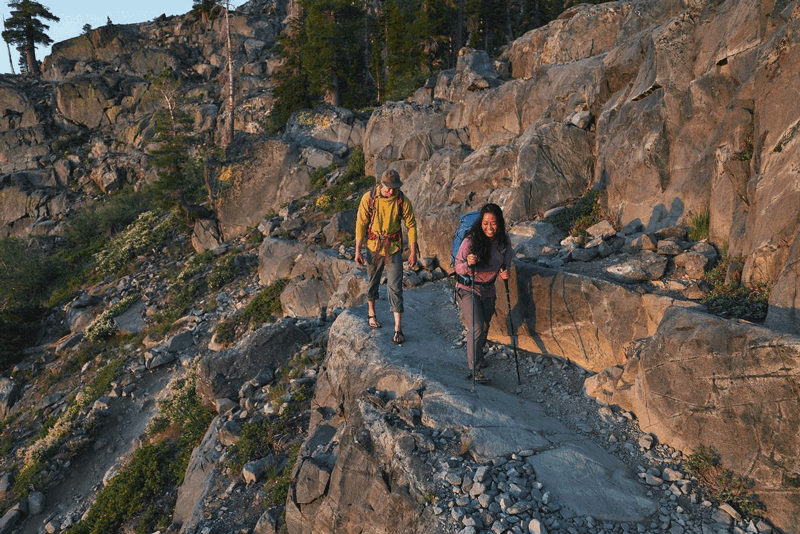 two people hiking in cairn sandals on a rocky trail